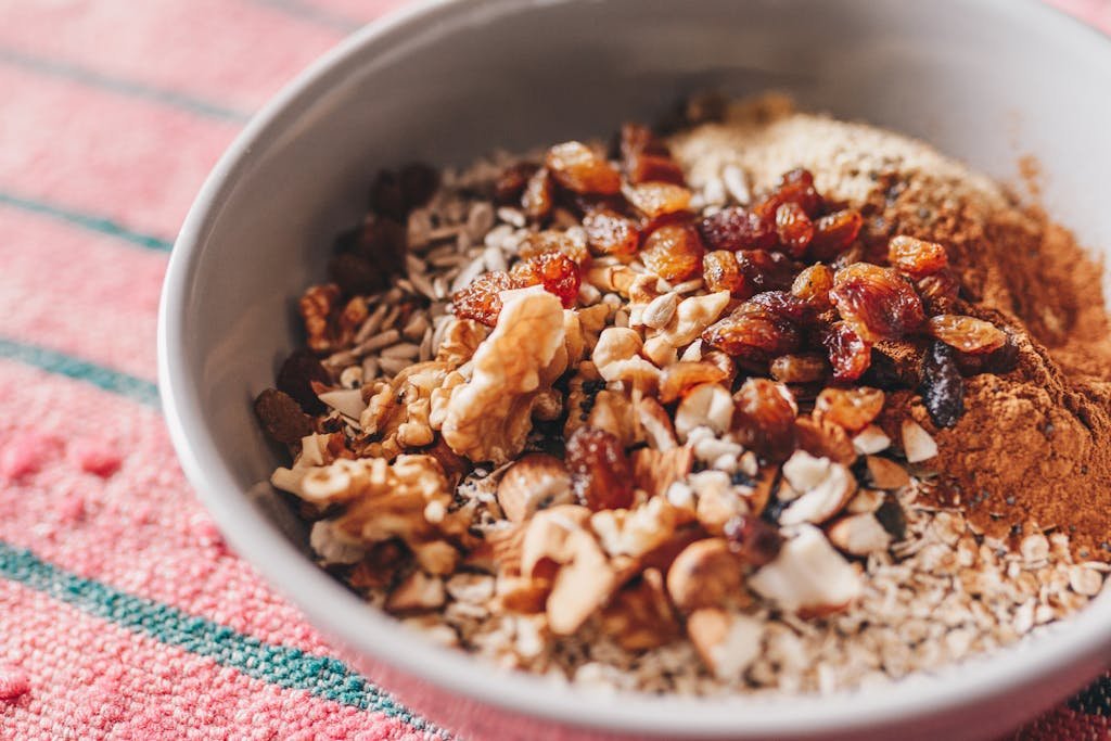 A nutritious oatmeal bowl topped with walnuts, sunflower seeds, and raisins.